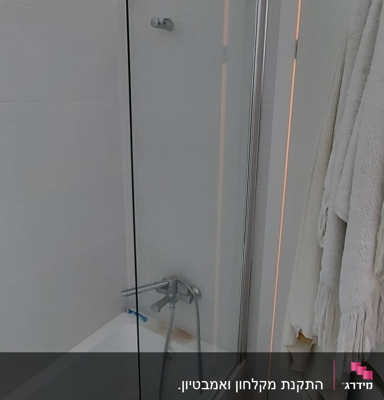 אמבטיה עם דלת זכוכית וברז מקלחת כסוף